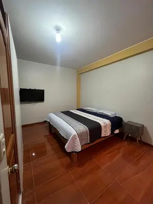 a bedroom with a bed and a television in it at 2da Habitacion a 1 cuadra de la Plaza in Oxapampa