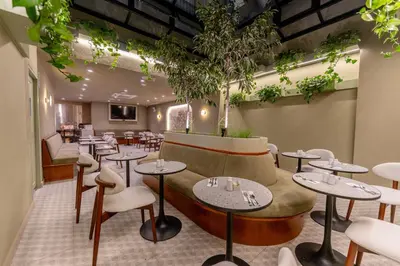 a restaurant with tables and chairs and plants at Hotel Límade in Lima