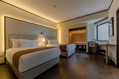a hotel room with two beds and a desk at Hotel Límade in Lima