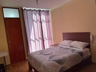a bedroom with a bed and a large window at HOTEL SAMANAHUASi in Nazca