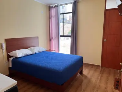 a bedroom with a blue bed and a window at HOTEL SAMANAHUASi in Nazca