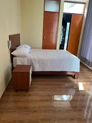 a bedroom with a large bed and a table at HOTEL SAMANAHUASi in Nazca