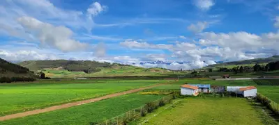 a green field with houses in the middle of it at Casa isaaleya in Cusco