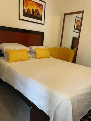 a bed with two yellow pillows on top of it at Hermoso Departamento en el mejor sector de Ica in Ica