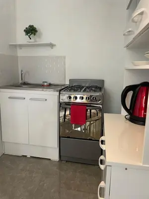 a kitchen with a stove with a red towel on it at Hermoso Departamento en el mejor sector de Ica in Ica