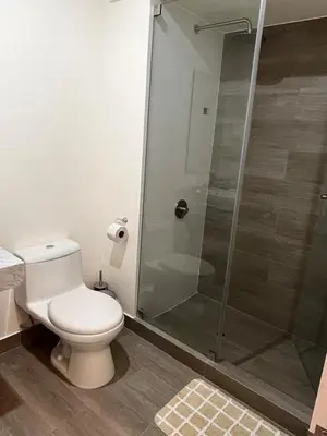 a bathroom with a toilet and a glass shower at Calm and beautiful apartment in San Isidro in Lima