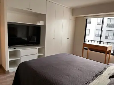 a bedroom with a bed and a flat screen tv at Calm and beautiful apartment in San Isidro in Lima