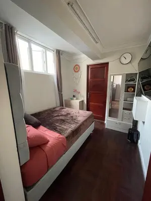 a bedroom with a bed and a window and a clock at Mini Apartment ARES in Lima