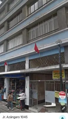 a building with a red flag in front of it at Mini Apartment ARES in Lima