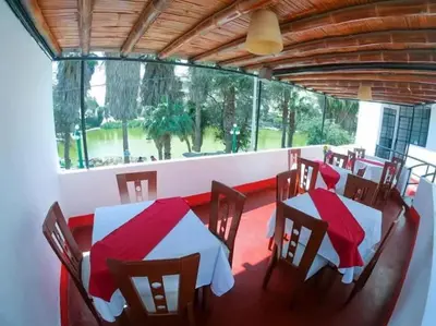 a restaurant with tables and chairs and a large window at Hospedaje snack bar titanic in Ica