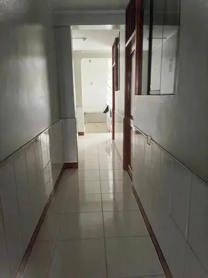 an empty hallway in a bathroom with white tiles at Hostal Wassiki in Huánuco