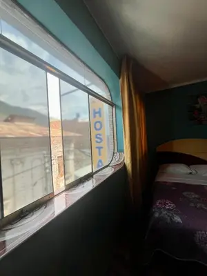 a room with a window with a bed at Hostal Wassiki in Huánuco