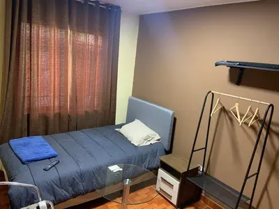 a small bedroom with a bed and a window at Family Home Furnished Centro Chincha Alta in Chincha Alta