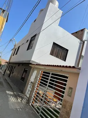 a white building with a gate in front of it at Family Home Furnished Centro Chincha Alta in Chincha Alta