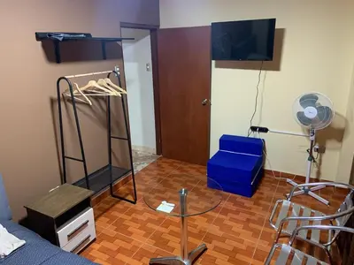 a room with a bed and a table and a fan at Family Home Furnished Centro Chincha Alta in Chincha Alta