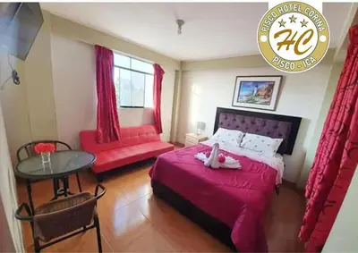 a bedroom with a bed and a table and a table at Pisco Hospedaje Corina in Pisco