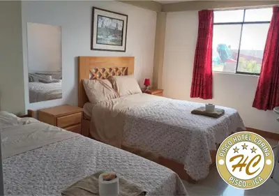 a small bedroom with two beds and a window at Pisco Hospedaje Corina in Pisco