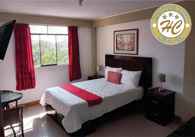 a bedroom with a large bed with red curtains at Pisco Hospedaje Corina in Pisco