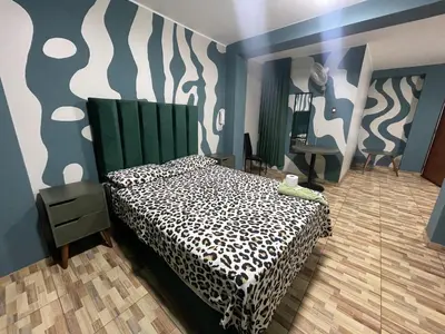a bedroom with a bed with a black and white comforter at Agora Hs in Chincha