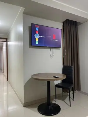 a room with a table and a tv on a wall at Agora Hs in Chincha