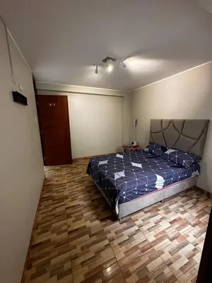 a bedroom with a bed and a wooden floor at Agora Hs in Chincha