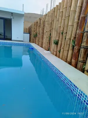a swimming pool with blue water in front of a building at CASA DE PLAYA FRENTE AL MAR k173 in San Vicente de Cañete
