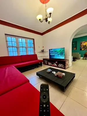 a living room with a red couch and a tv at Hostel rivendell lima in Lima