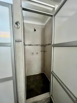 a walk in shower with a glass door in a bathroom at Hostel rivendell lima in Lima