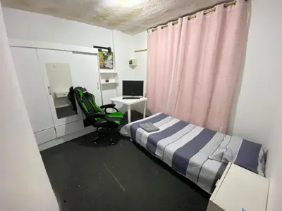 a bedroom with a bed and a desk with a computer at Habitación con baño particular, lindas áreas comunes in Lima