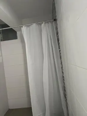 a shower with a white shower curtain in a bathroom at Ocean View Premiere Depa Naplo in Naplo