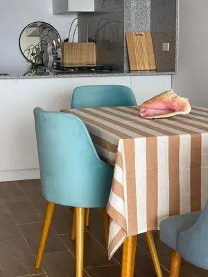 a dining room table with two blue chairs and a striped table cloth at Ocean View Premiere Depa Naplo in Naplo