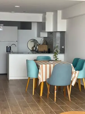 a kitchen with a table and some blue chairs at Ocean View Premiere Depa Naplo in Naplo