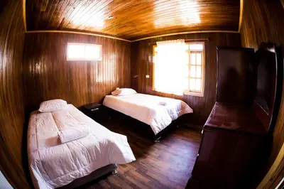 a small room with two beds and a window at Edelweiss Haus in Chontabamba