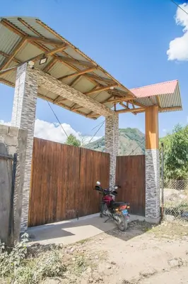 a motorcycle parked under a wooden fence at Edelweiss Haus in Chontabamba