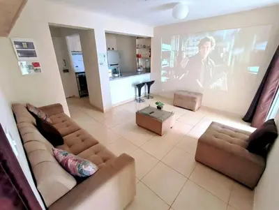 a living room with two couches and a large screen at Departamento Playa Arica - Lurín in Lurín
