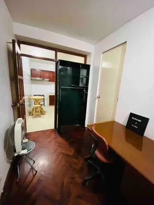 an office with a desk and a refrigerator in a room at Minidepartamento La Molina Junin 1 in Lima