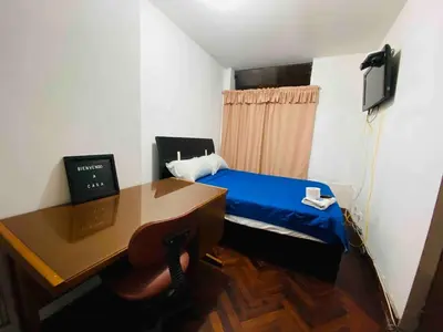 a small room with a desk and a bed and a computer at Minidepartamento La Molina Junin 1 in Lima