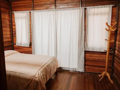 a bedroom with a bed and a window with curtains at HOSPEDAJE CasaBlanca Huacachina in Ica