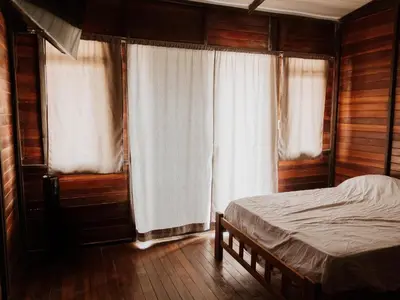 a bedroom with a bed and two windows at HOSPEDAJE CasaBlanca Huacachina in Ica