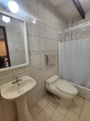 a bathroom with a white toilet and a sink at Amplia habitación independiente con baño privado in Lima