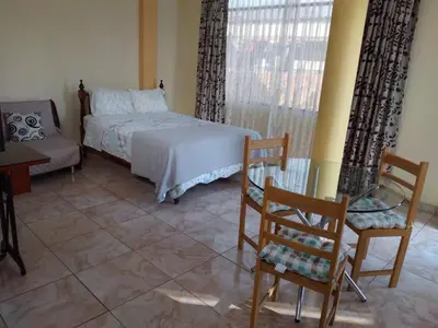 a bedroom with a bed and a table and chairs at Nice stay in Los Olivos in Lima