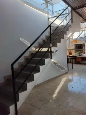 a staircase in a house with a glass railing at Nice stay in Los Olivos in Lima