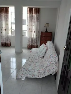 a bedroom with a bed and a dresser and windows at Comfortable stay in Los Olivos in Lima
