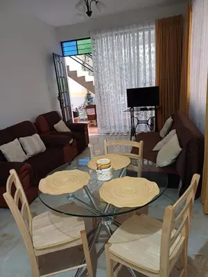 a living room with a glass table and chairs at Family accommodation in Lima