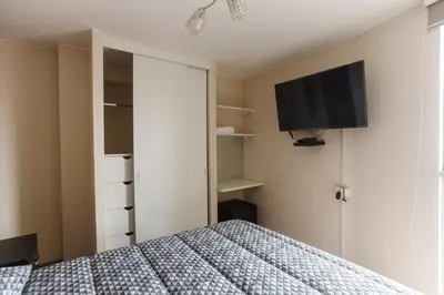 a bedroom with a bed and a tv on the wall at Vista piloto cerca Miraflores y Centro Histórico, seguridad 24 h in Lima