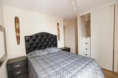 a bedroom with a bed with a black headboard at Vista piloto cerca Miraflores y Centro Histórico, seguridad 24 h in Lima