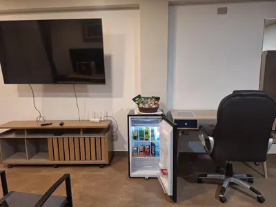a refrigerator in an office with a desk and a chair at Hotel MAXIMUM COMFORT FCA in Salinas