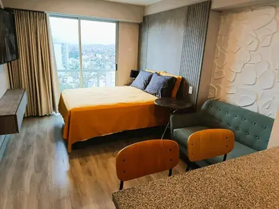 a hotel room with a bed and a chair and a window at LA POSADA DE GUILLE - JAVIER PRADO Este 1501 in Lima
