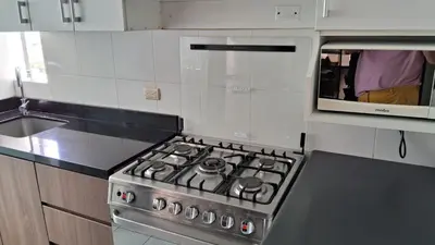 a kitchen with a stove and a microwave at El Derby 511 Apart 2 Dorm con Aire Acondicionado in Lima