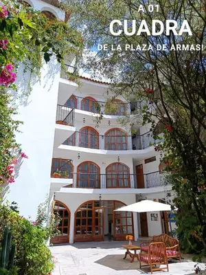 a large white building with a table in front of it at Casa Munayki in Ayacucho